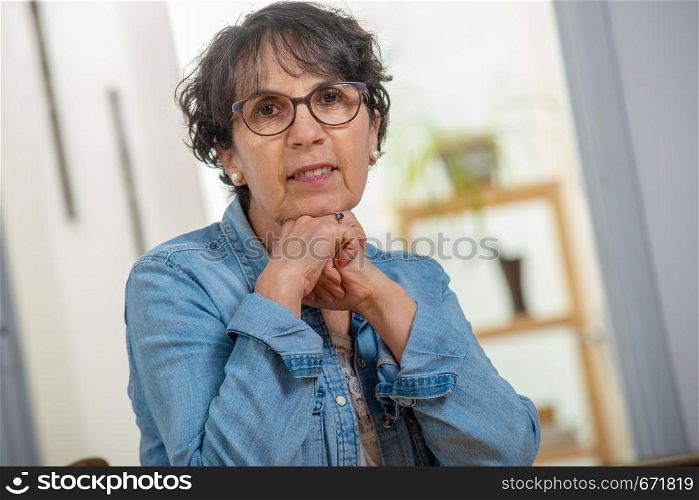 portrait of a senior brunette with a jeans jacket
