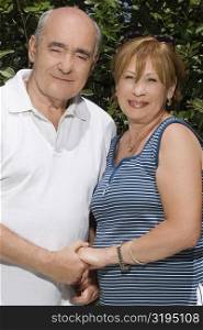 Portrait of a senior couple holding hands and smiling
