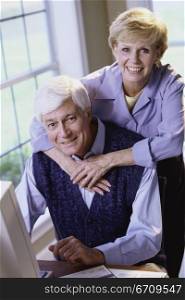 Portrait of a senior couple together in front of a computer