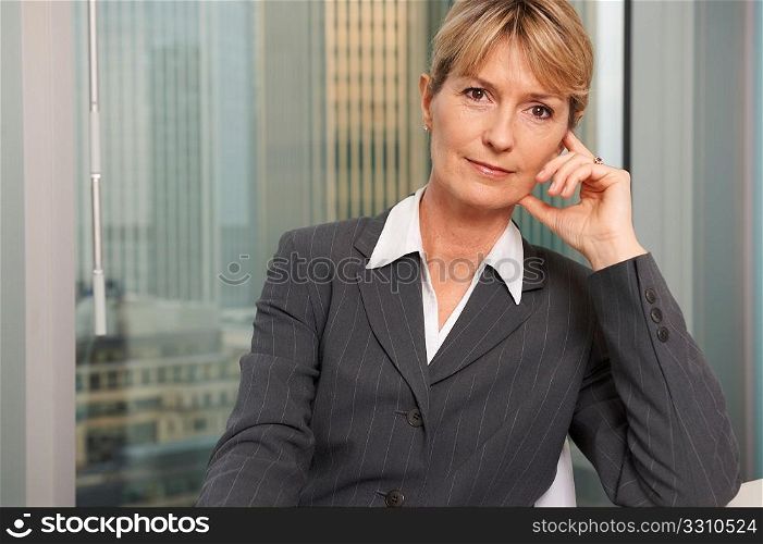 Portrait of a senior executive by a window smiling looking at camera