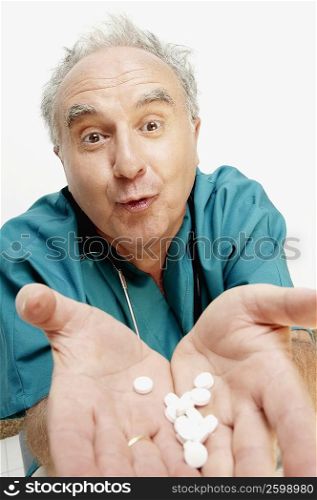 Portrait of a senior male doctor showing tablets