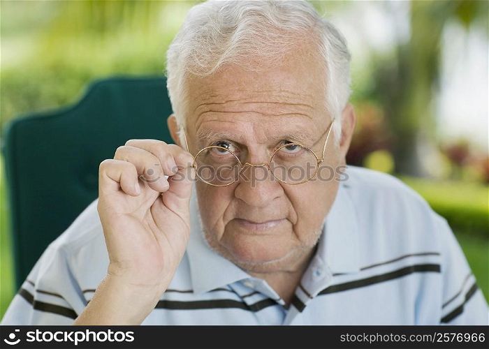 Portrait of a senior man adjusting his eyeglasses