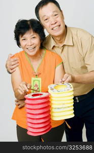 Portrait of a senior man and a mature woman holding Chinese lanterns