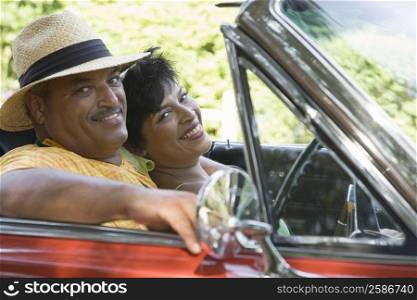 Portrait of a senior man and a mature woman sitting in a convertible car