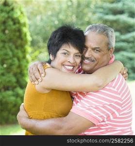 Portrait of a senior man embracing with a mature woman and smiling