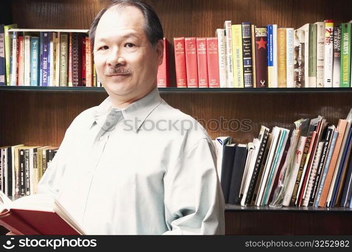 Portrait of a senior man holding a book