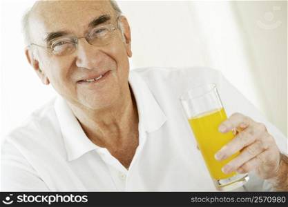 Portrait of a senior man holding a glass of juice