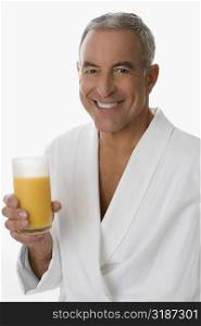 Portrait of a senior man holding a glass of orange juice and smiling