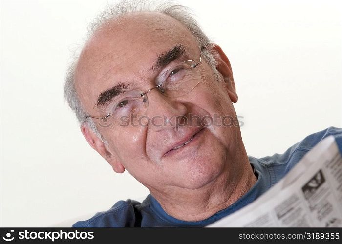 Portrait of a senior man holding a newspaper