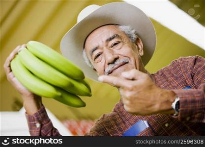 Portrait of a senior man holding bananas