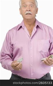 Portrait of a senior man holding paper currencies