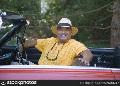 Portrait of a senior man sitting in a convertible car and smiling