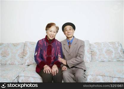 Portrait of a senior man sitting on a couch with a mature woman