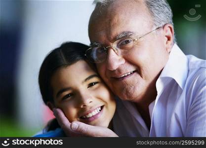 Portrait of a senior man smiling with his granddaughter