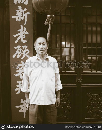 Portrait of a senior man standing in front of a restaurant