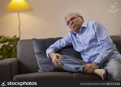 Portrait of a senior man suffering from knee pain 	