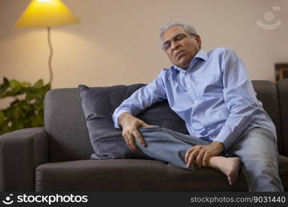 Portrait of a senior man suffering from knee pain 	