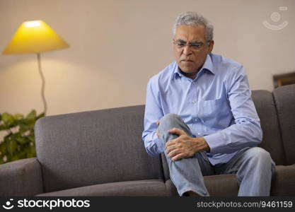 Portrait of a senior man suffering from knee pain 