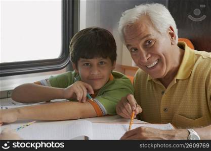 Portrait of a senior man teaching his grandson and smiling