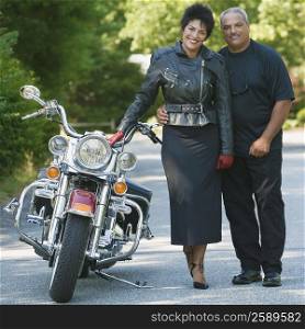 Portrait of a senior man with a mature woman standing beside a motorcycle