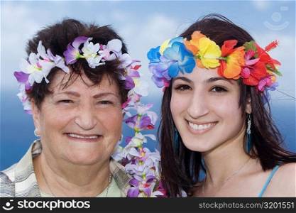 Portrait of a senior woman and her daughter wearing flowers