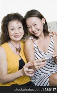 Portrait of a senior woman and her granddaughter sitting together and smiling
