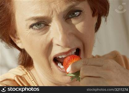 Portrait of a senior woman eating a strawberry
