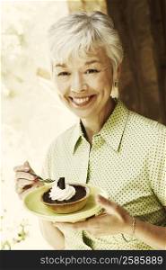 Portrait of a senior woman eating a tart with a fork