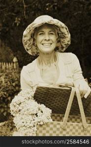 Portrait of a senior woman holding a basket of flowers and smiling