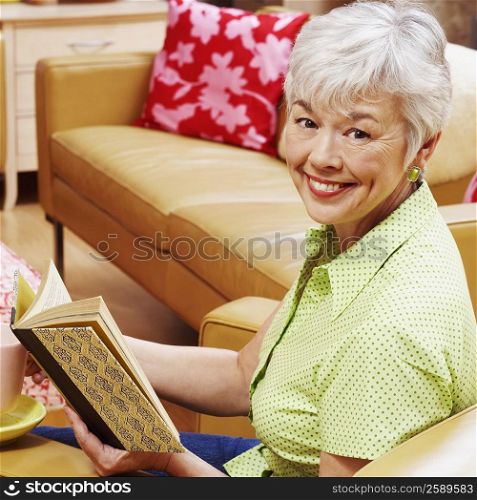 Portrait of a senior woman holding a book and smiling