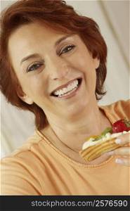 Portrait of a senior woman holding a fruit tart