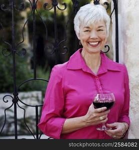 Portrait of a senior woman holding a glass of red wine