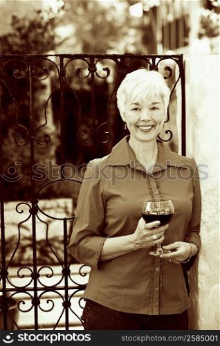 Portrait of a senior woman holding a glass of red wine