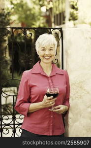 Portrait of a senior woman holding a glass of red wine