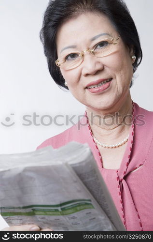 Portrait of a senior woman holding a newspaper