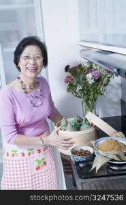 Portrait of a senior woman holding dumplings in a bamboo steamer