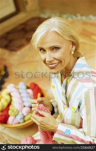Portrait of a senior woman knitting and smiling