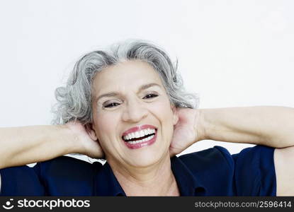 Portrait of a senior woman laughing with her hands behind her head