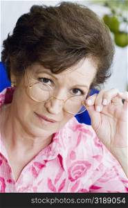 Portrait of a senior woman peeking over her eyeglasses