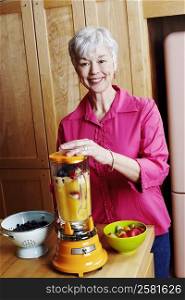 Portrait of a senior woman preparing mango shake in the kitchen
