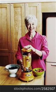 Portrait of a senior woman preparing mango shake in the kitchen