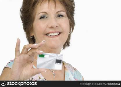 Portrait of a senior woman showing a credit card and smiling