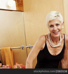 Portrait of a senior woman sitting in front of a mirror and smiling