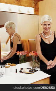 Portrait of a senior woman sitting in front of a mirror in the bathroom and smiling