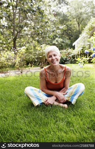 Portrait of a senior woman sitting on grass and smiling