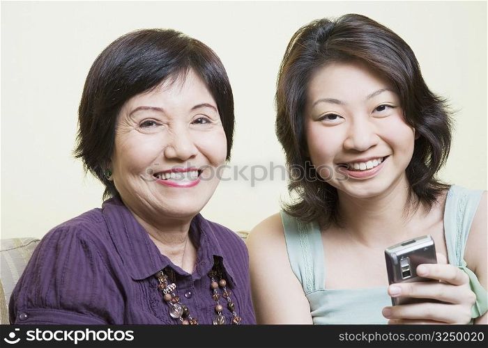 Portrait of a senior woman sitting with her granddaughter and smiling