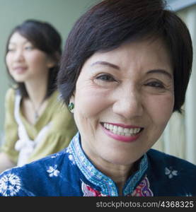 Portrait of a senior woman smiling with her granddaughter standing behind her