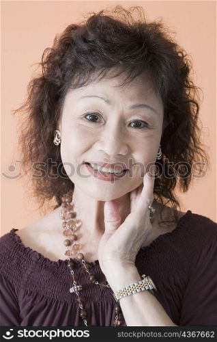 Portrait of a senior woman smiling with her hand on her chin