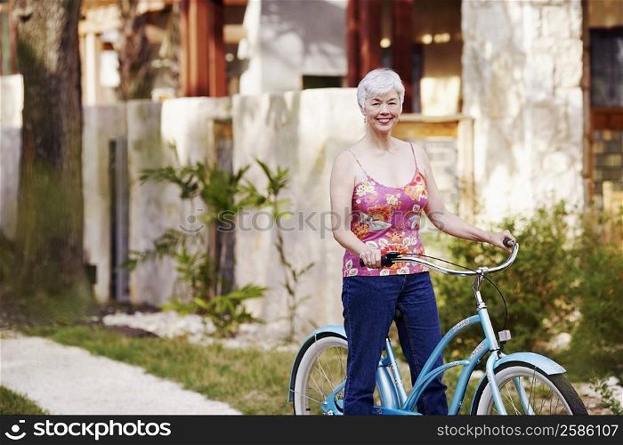 Portrait of a senior woman standing with a bicycle