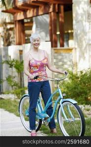 Portrait of a senior woman standing with a bicycle